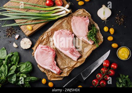 Mehrere rohe Schweinefleisch-Steaks auf Backpapier Stockfoto