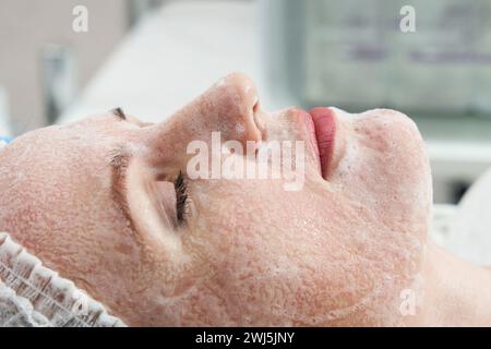 Junge hübsche Frau, die Behandlungen in Schönheitssalons erhält. Mit Gesichtsreinigungsschaum Stockfoto