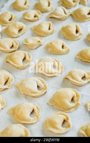 Hausgemachte Teigtaschen auf weißem Leinentuch Stockfoto