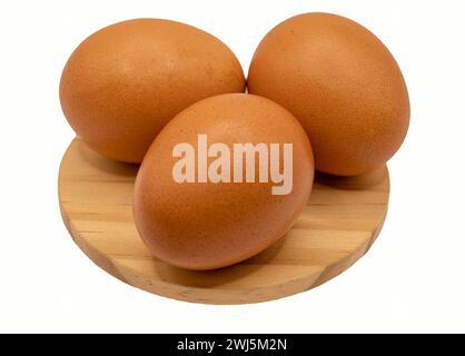 Frische Eier, auf einem Pinienholz-Hintergrund angeordnet, bereit für die Osterfeier. Ihr lebhafter Kontrast zum natürlichen Holz Stockfoto