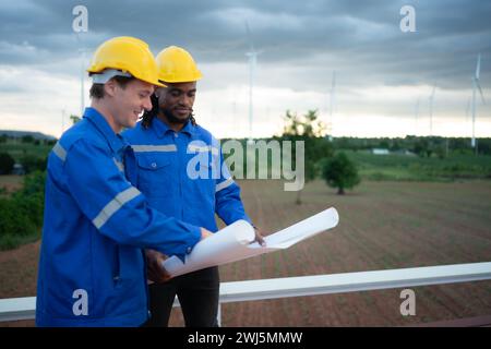 Rückansicht eines Ingenieurs und Technikers, der Windkraftanlagen vor Ort betrachtet, bevor er die Windkraftanlage überprüft, das Konzept von n Stockfoto