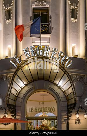 Nächtliche Aufnahme des geschwungenen, mit Glasdach versehenen Eintrittsschildes zum berühmten Le Negresco Hotel und Restaurant an der Promenade des Anglais, Nizza, Frankreich. Stockfoto