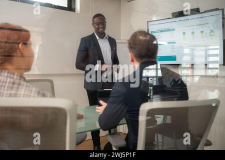 Rückansicht von zwei Geschäftsleuten, die sich um den Tisch im Büro treffen Stockfoto