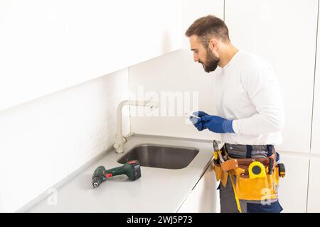 Klempner installiert Küchenarmatur. Sanierung in der Wohnung. Stockfoto