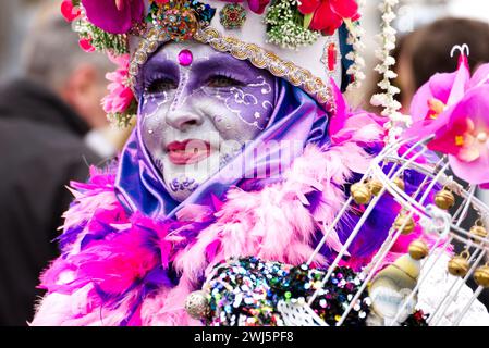 Maastricht, Niederlande. Februar 2024. Eine Frau mit farbenfroher Gesichtsfarbe und auffälligem Kostüm nimmt am Karnevalssonntag in Maastricht Teil. Anna Carpendale/Alamy Live News Stockfoto