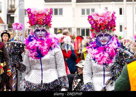 Maastricht, Niederlande. Februar 2024. Zwei Frauen mit farblich abgestimmter Gesichtsfarbe und auffälligen Kostümen nehmen an der Parade in Maastricht am Karnevalssonntag Teil. Anna Carpendale/Alamy Live News Stockfoto