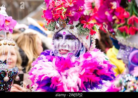 Maastricht, Niederlande. Februar 2024. Eine Frau mit farbenfroher Gesichtsfarbe und auffälligem Kostüm nimmt am Karnevalssonntag in Maastricht Teil. Anna Carpendale/Alamy Live News Stockfoto