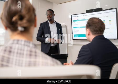 Rückansicht von zwei Geschäftsleuten, die sich um den Tisch im Büro treffen Stockfoto