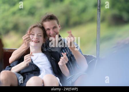Ein junges Paar sitzt auf einem Boot für eine Reise in den Wald über dem Damm zum Trekking. Stockfoto
