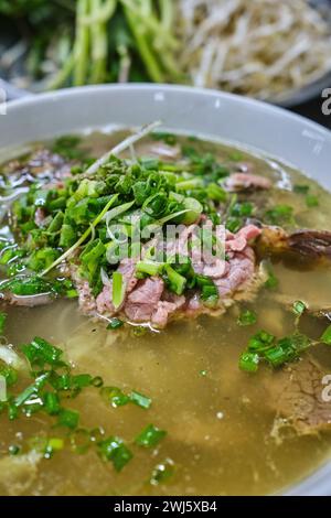 Eine Schüssel Rindfleisch Pho (phở) serviert mit Gemüsewürzen Stockfoto