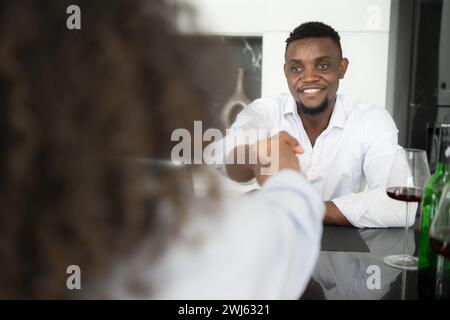 Beide jungen Unternehmen trinken Wein und nutzen ihre Laptops, um Informationen in ihrem Wohnzimmer miteinander zu teilen. Stockfoto