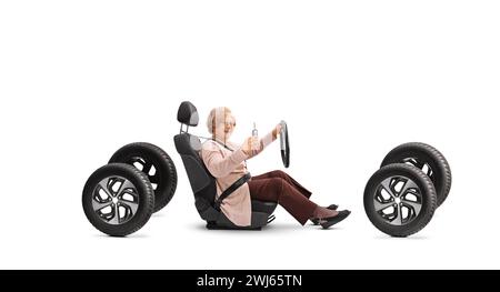 Ältere Frau, die auf einem Autositz sitzt und einen Schlüssel auf weißem Hintergrund zeigt Stockfoto