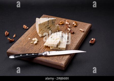 Köstlicher Frischkäse mit Blauschimmeldorblu auf einem hölzernen Schneidebrett Stockfoto