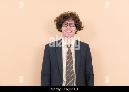 Porträt eines hübschen jungen Mannes mit lockigen Haaren auf beigefarbenem Hintergrund Stockfoto