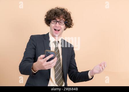 Porträt eines hübschen jungen Mannes mit lockigen Haaren auf beigefarbenem Hintergrund Stockfoto