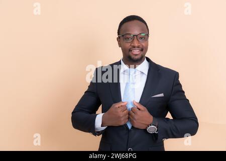 Porträt eines selbstbewussten afroamerikanischen Geschäftsmannes, der mit überkreuzten Armen steht. Stockfoto