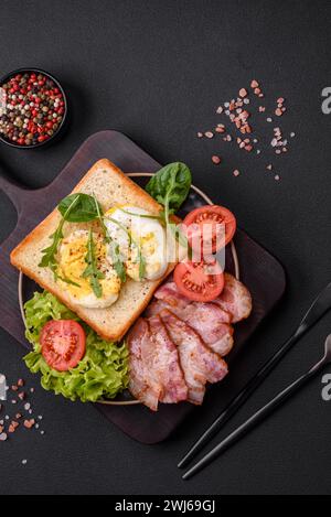 Köstliches gesundes Mittagessen bestehend aus Speck, Toast, Eiern und Tomaten Stockfoto