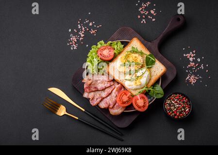 Köstliches gesundes Mittagessen bestehend aus Speck, Toast, Eiern und Tomaten Stockfoto