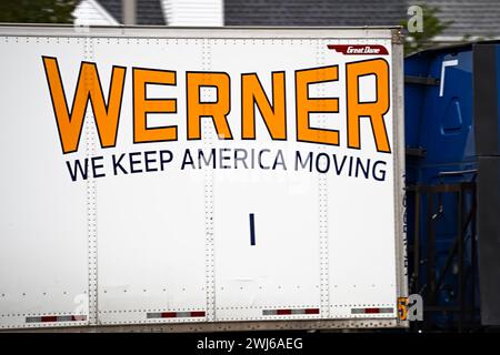 New York, NY - 27. Oktober 2023: Werner Enterprises, Inc Logos der amerikanischen Logistikfirma auf dem Lastwagen auf der Autobahn. Stockfoto