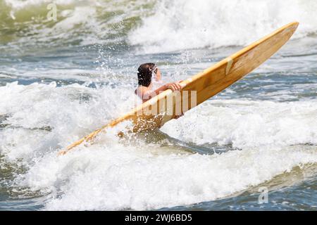 Weibliche Surfer werden von Wellen getroffen, die versuchen, in den Atlantik zu kommen, um zu surfen. Stockfoto