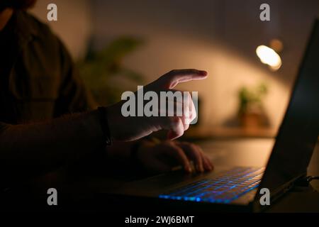 Nahaufnahme Eines Mannes, Der Nachts Zu Hause Ein Notebook Benutzt, Mit Dem Finger Zum Touchscreen Streckt Stockfoto