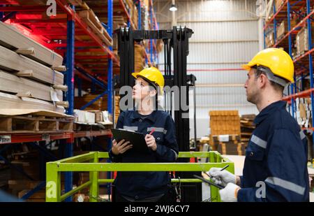 Lagerarbeiter, die Gabelstapler verwenden, um in einem großen Lager zu prüfen und zu zählen. Hierbei handelt es sich um eine große Lagerung und Verteilung von Papierverpackungen Stockfoto