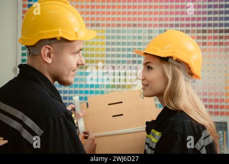 Lagerarbeiter in Uniform und Schutzhelm, die in einer Papierfabrik arbeiten Stockfoto