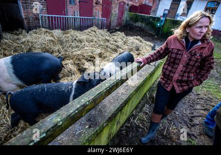 Ruhner Berge, Deutschland. Februar 2024. Steffi Lemke (Bündnis 90/die Grünen), Bundesminister für Umwelt, Naturschutz, Reaktorsicherheit und Verbraucherschutz, steht am Schweinestall eines Bio-Milchbetriebs im Ruhn-Gebirge an der Grenze zwischen Brandenburg und Mecklenburg-Vorpommern. Der Siebengiebelhof ist ein kleiner Bauernhof mit 25 Weidekühen, eigener Käserei, Direktvermarktung und biologischer Landwirtschaft. Quelle: Jens Büttner/dpa/Alamy Live News Stockfoto