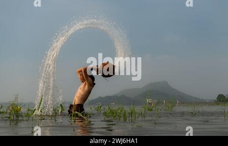 Fischer, die nach dem Fang von Fischen traditionelle Fangausrüstung verwenden, reinigen und spielen im Wasser. Stockfoto