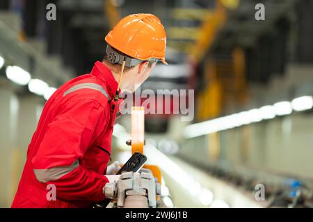 Nachdem der Elektrozug in der Werkstatt für Elektrozüge geparkt wurde, inspiziert ein Elektrozugtechniker mit Werkzeugen die Eisenbahn Stockfoto