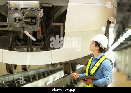 Nachdem der Elektrozug in der Werkstatt des Elektrozugs geparkt ist, inspiziert der Elektrozugnachingenieur den Elektrozug Stockfoto