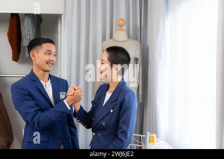 Beide asiatischen Modedesigner arbeiten mit Nähmaschinen im Hochzeitskleiderladen Stockfoto