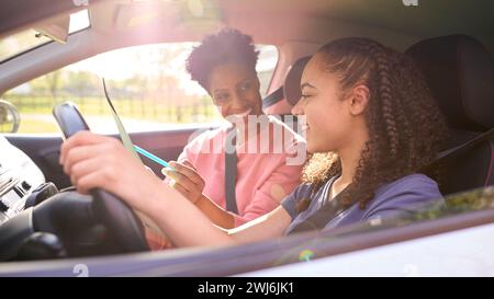 Teenager-Mädchen Im Auto, Die Fahrstunde Von Weiblicher Ausbilderin Hat Stockfoto