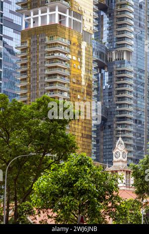 Uhrenturm des Lau Pa Sat Markts in Singapur mit modernen Bürogebäuden im Hintergrund. Stockfoto