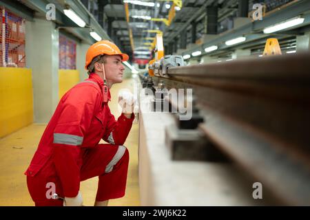 Nachdem der Elektrozug in der Werkstatt für Elektrozüge geparkt wurde, inspiziert ein Elektrozugtechniker mit Werkzeugen die Eisenbahn Stockfoto