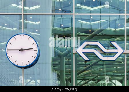 Den Haag, Niederlande - 31. Januar 2024: Eisenbahnuhr und Logo der niederländischen Eisenbahnen vor dem Hauptbahnhof in den Haag, Niederlande Stockfoto