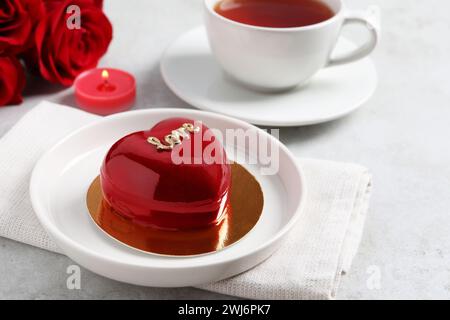 St. Valentinstag. Köstlicher herzförmiger Kuchen, serviert auf Lichttisch, Nahaufnahme Stockfoto
