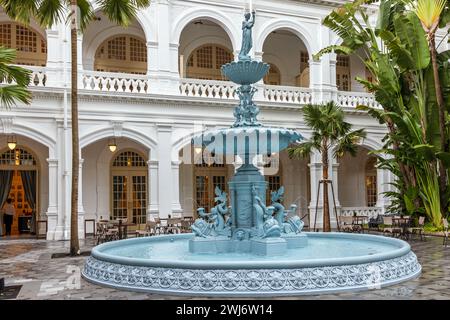 Kunstvoller gusseiserner Wasserbrunnen im Innenhof des berühmten Raffles Hotels in Singapur Stockfoto