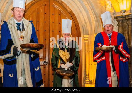 London, Großbritannien. Februar 2024. Die jährlichen Inter-Livery Pancake-Rennen in der Regel Guildhall Yard am Faschingsdienstag, aber dieses Jahr wurde wegen des regnerischen Wetters in die Krypta verlegt. Teams, die entweder schicke Kleidung oder volle Insignien tragen, rennen um den Guildhall Yard herum und werfen ihre Pfannkuchen. Der Wettbewerb findet seit über 15 Jahren jährlich statt, und die Erlöse fließen an wohltätige Zwecke. Guy Bell/Alamy Live News Stockfoto