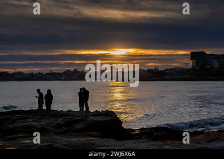 Menschen an Land im Estoril Resort mit Blick auf die Stadt Cascais bei Sonnenuntergang am Atlantischen Ozean im Bezirk Lissabon, Portugal. Stockfoto
