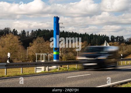 LKW-Mauterfassungsstelle auf Landstraße B8 bei Selters 13.02.24, Selters: Symbolfoto, Illustrationsbild, Symbolbild, Illustrationsfoto LKW-Mauterfassungsstelle auf Landstraße B8 bei Selters ein Bild zeigt eine blaue Stehle zur Erfassung der LKW-Maut auf der Landstraße B8 bei Selters. Autos fahren an der Mautstelle vorbei, die aufgrund Ihrer Erscheinung häufig mit einem festen Blitzer zur Geschwindigkeitsüberwachung verwechselt wird. Die Szene vermittelt einen Einblick in die alltägliche Verkehrssituation und die technischen Einrichtungen zur Mauterfassung auf deutschen Straßen Selters Hessen G Stockfoto