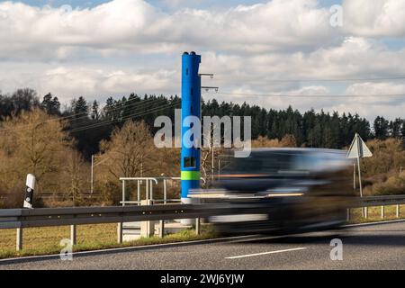 LKW-Mauterfassungsstelle auf Landstraße B8 bei Selters 13.02.24, Selters: Symbolfoto, Illustrationsbild, Symbolbild, Illustrationsfoto LKW-Mauterfassungsstelle auf Landstraße B8 bei Selters ein Bild zeigt eine blaue Stehle zur Erfassung der LKW-Maut auf der Landstraße B8 bei Selters. Autos fahren an der Mautstelle vorbei, die aufgrund Ihrer Erscheinung häufig mit einem festen Blitzer zur Geschwindigkeitsüberwachung verwechselt wird. Die Szene vermittelt einen Einblick in die alltägliche Verkehrssituation und die technischen Einrichtungen zur Mauterfassung auf deutschen Straßen Selters Hessen G Stockfoto