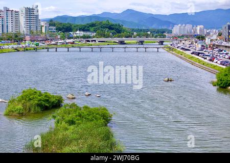 Gangneung City, Südkorea - 29. Juli 2019: Beim Blick auf den Namdae Stream im Zentrum von Gangneung fließt das weite Wasser des Baches ruhig mit Bergen Stockfoto