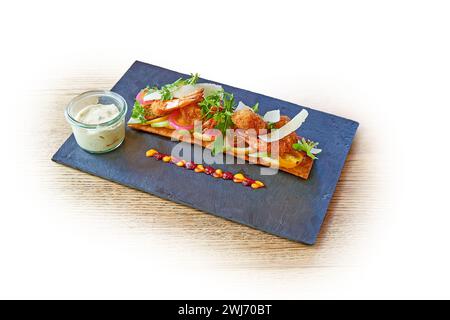 Schwarze Schieferplanke mit gebratenen Garnelen und Tartarsauce isoliert auf weiß Stockfoto
