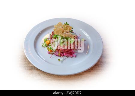 Weiße Platte mit Rindfleisch-amerikanischem Tatar isoliert auf weiß Stockfoto