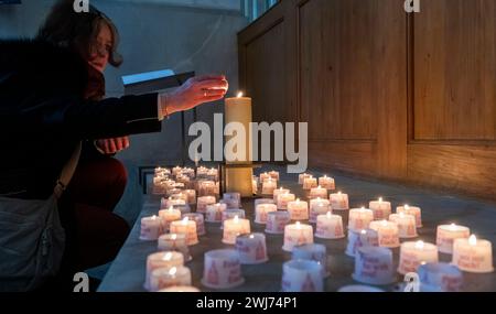 Dresden, Deutschland. Februar 2024. Ein Kirchgänger zündet in der Frauenkirche eine Kerze an. Den ganzen Tag über finden in der Stadt Gedenkveranstaltungen zum 79. Jahrestag des Bombenanschlags auf Dresden statt. Quelle: Matthias Rietschel/dpa-Zentralbild/dpa/Alamy Live News Stockfoto