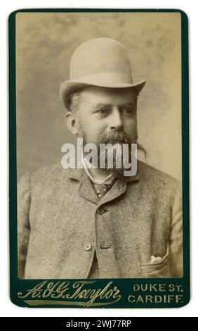 Original viktorianischer CDV Carte de Visite (Visitenkarte oder CDV) eines angenehm aussehenden bärtigen Waliser viktorianischen Mannes, der einen hellen Bowler Hut mit hoher Krone, einen „Sack Anzug“, oben befestigt, Krawatte, Taschentasche (neu in den 1880er Jahren) aus dem Studio von A & G Taylor trägt, Duke St, Cardiff, Wales, Großbritannien ca. Mitte der 1880er Jahre Stockfoto