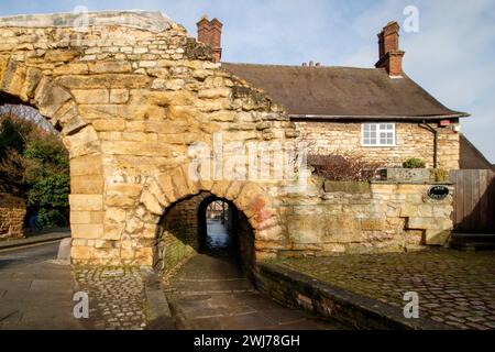 Der Newport Arch und die Straße nach Bailgate im oberen Bereich von Lincoln. Newport Arch ist ein römisches Tor aus dem 3. Jahrhundert in Lincoln, Lincolnshire. Es handelt sich um ein Scheduled Monument und ein denkmalgeschütztes Gebäude, das angeblich der älteste Bogen im Vereinigten Königreich ist, der noch vom Verkehr genutzt wird. Stockfoto