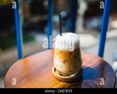 Kaffee, Eiskaffee im Glas Milch oder Sahne mitgeben. Auf einem Holztisch in einem Café. Stockfoto