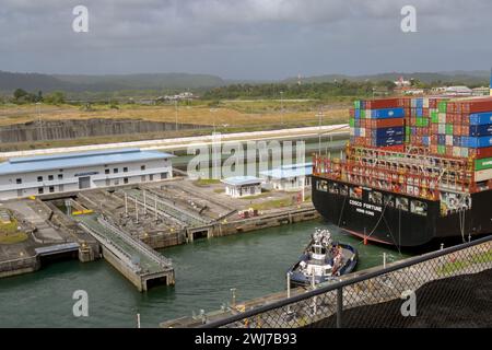 Colon, Panama - 22. Januar 2024: Schlepper, die einem großen Containerschiff Costco Fortune bei der Durchfahrt der Schleusen der Agua Clara auf dem Panamakanal helfen Stockfoto